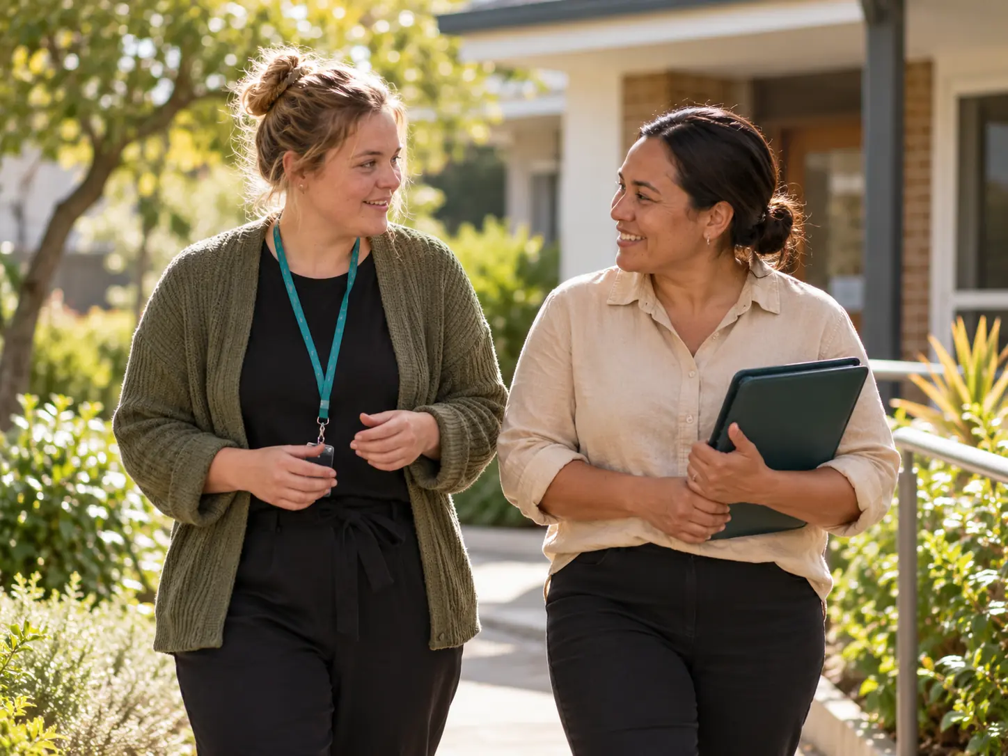A support coordinator and participant walking together outdoors.